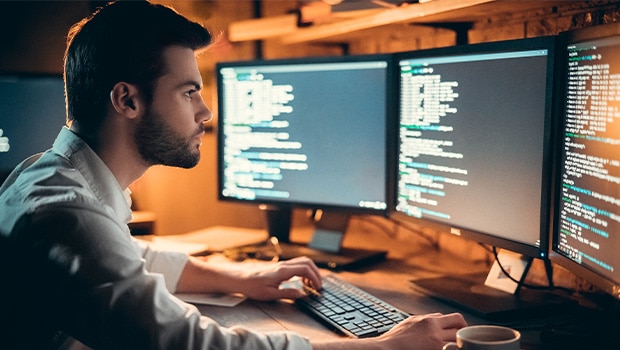 software developer using monitors looking for dangers of unsecured code