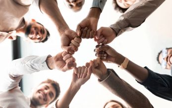 business ethics training course in which team of diverse people are doing fist bump